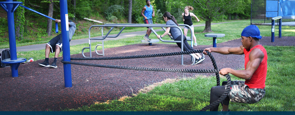 Photo of student working out on outdoor fitness equipment
