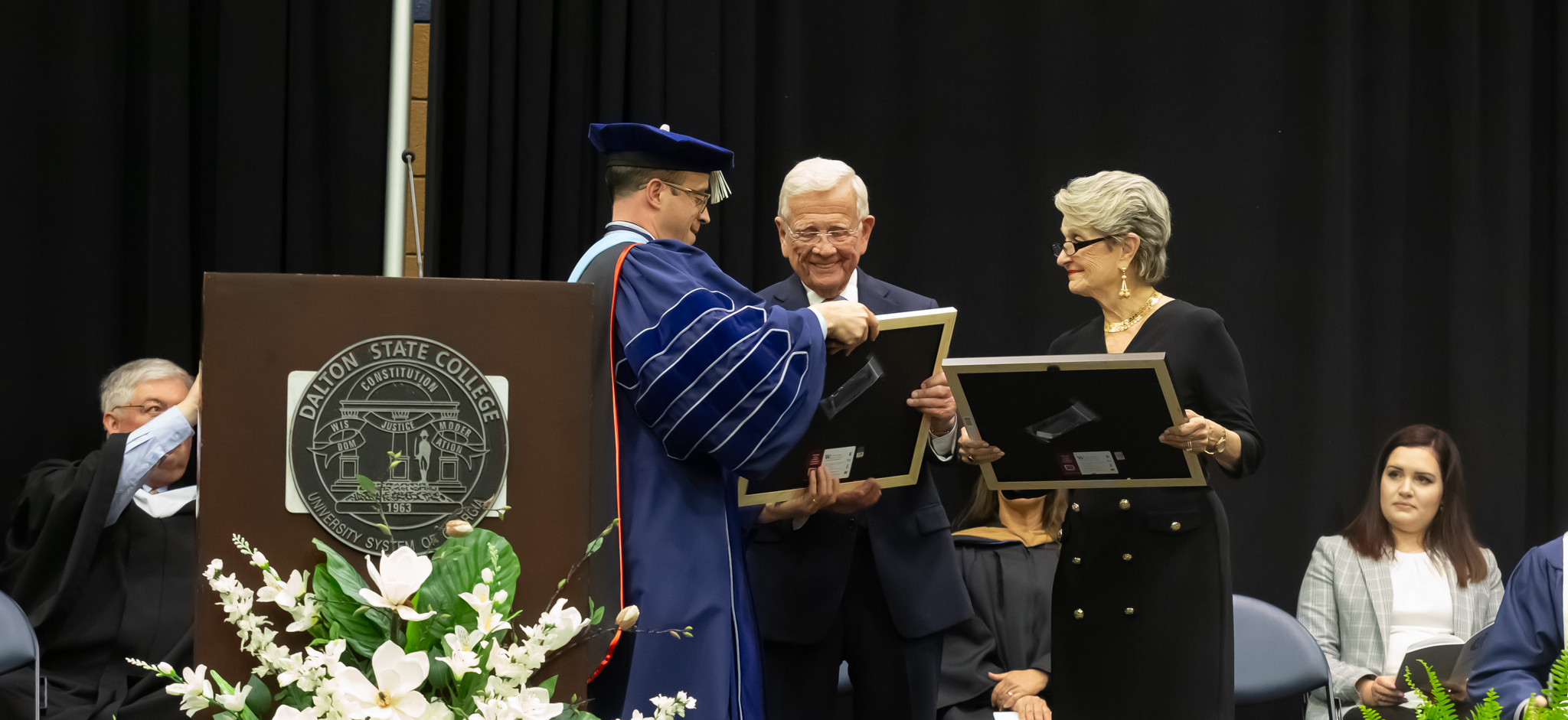 Dalton State President John Fuchko (left) presented Bob Shaw (center) and Dottie Shaw each with an Honorary Doctor of Business Administration degree during the college’s spring 2024 commencement exercises on May 14.