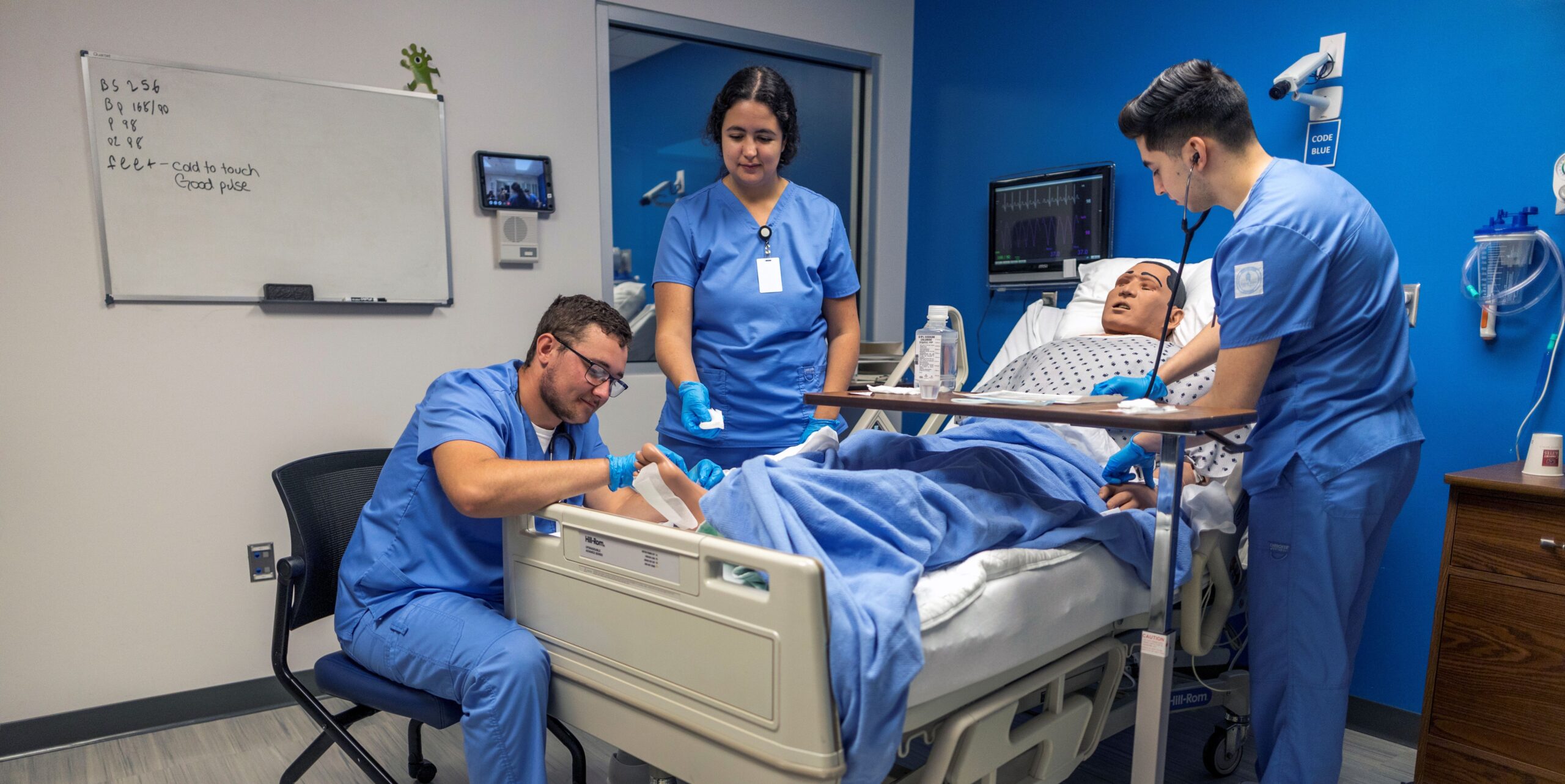 Nursing students practice patient care on a manikin.